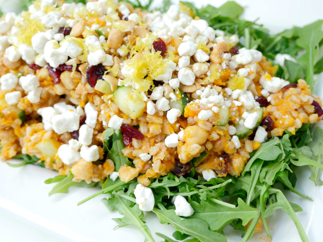 Happily Brenda After Autumn Farro Salad with Sweet Potato, Cucumber, Chickpeas, cranberries, goat cheese, cashews, arugula, and lemon zest phtographed in a marble kitchen 