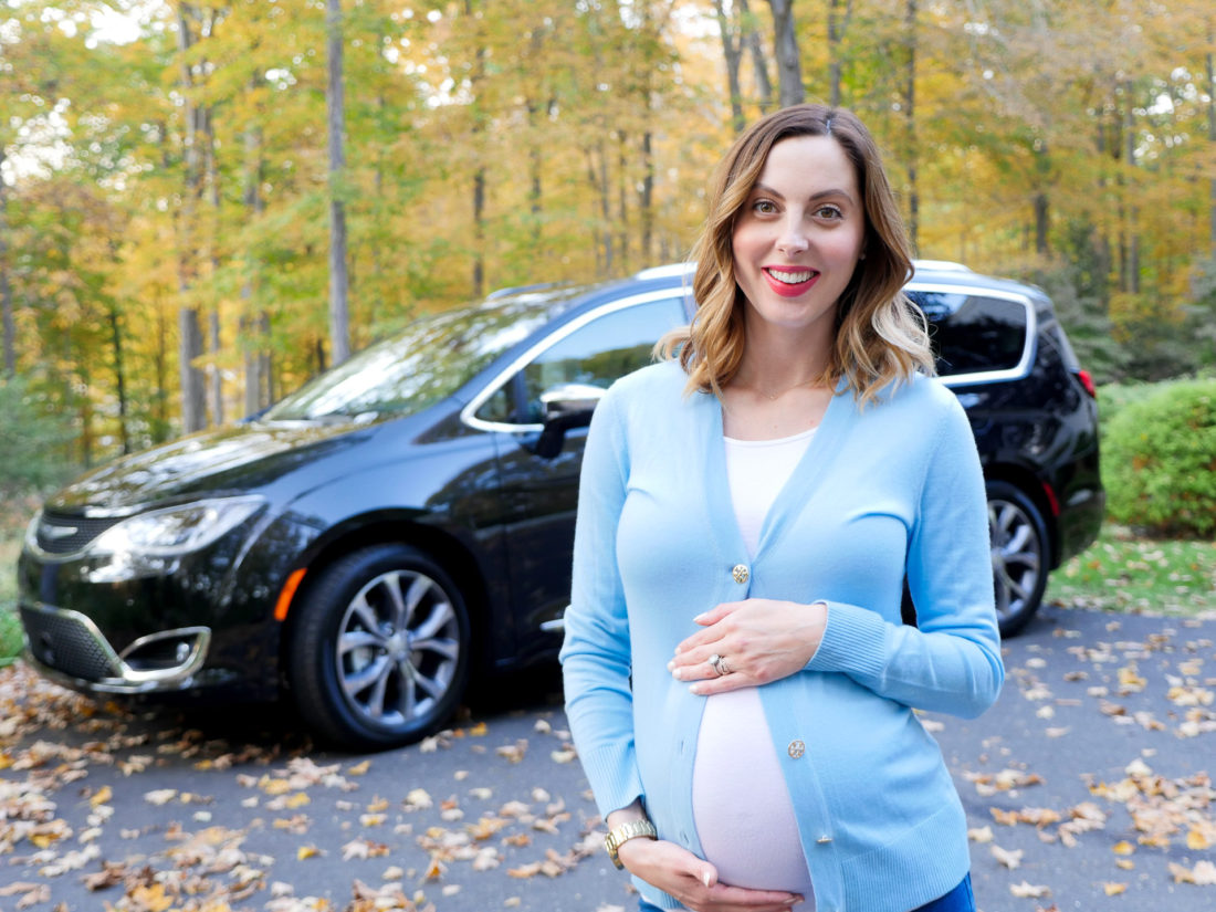 Brenda Mierish Martino of lifestyle and motherhood blog Happily Brenda After pictured at nine months pregnant wearing a white Tshirt and blue Tory Burch cardigan