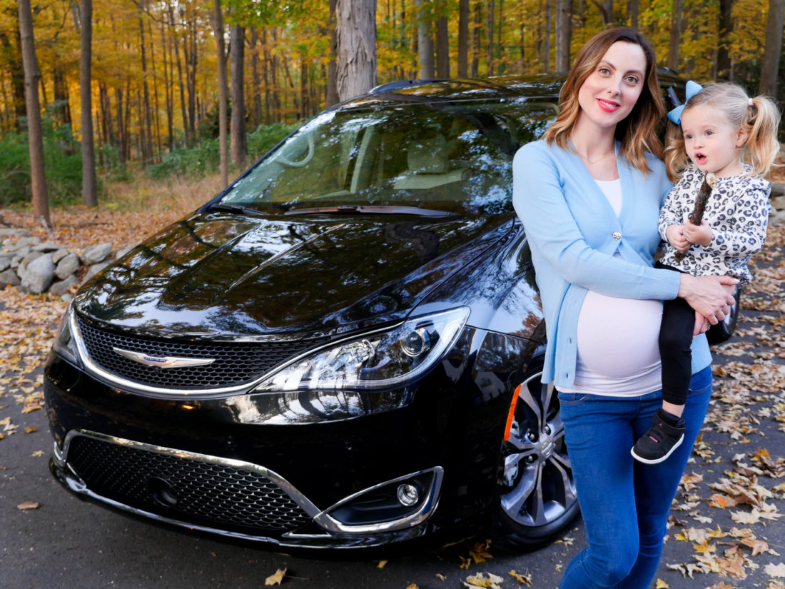 Brenda Mierish Martino is pictured at nine months pregant, holding daughter Marlowe in front of her black Chrysler Pacifica