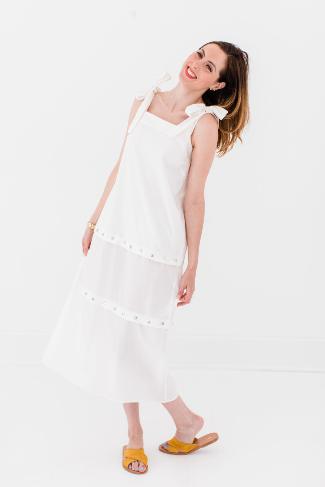 Brenda Mierish Martino wears an adjustable white snap dress with bow straps as part of a post about packing simply