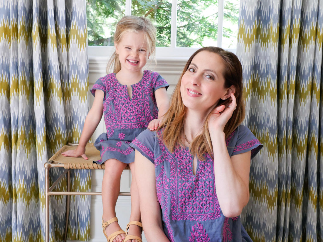 Brenda Mierish Martino and Marlowe Martino wear matching embroidered dresses and sit together in the living room of their Connecticut home