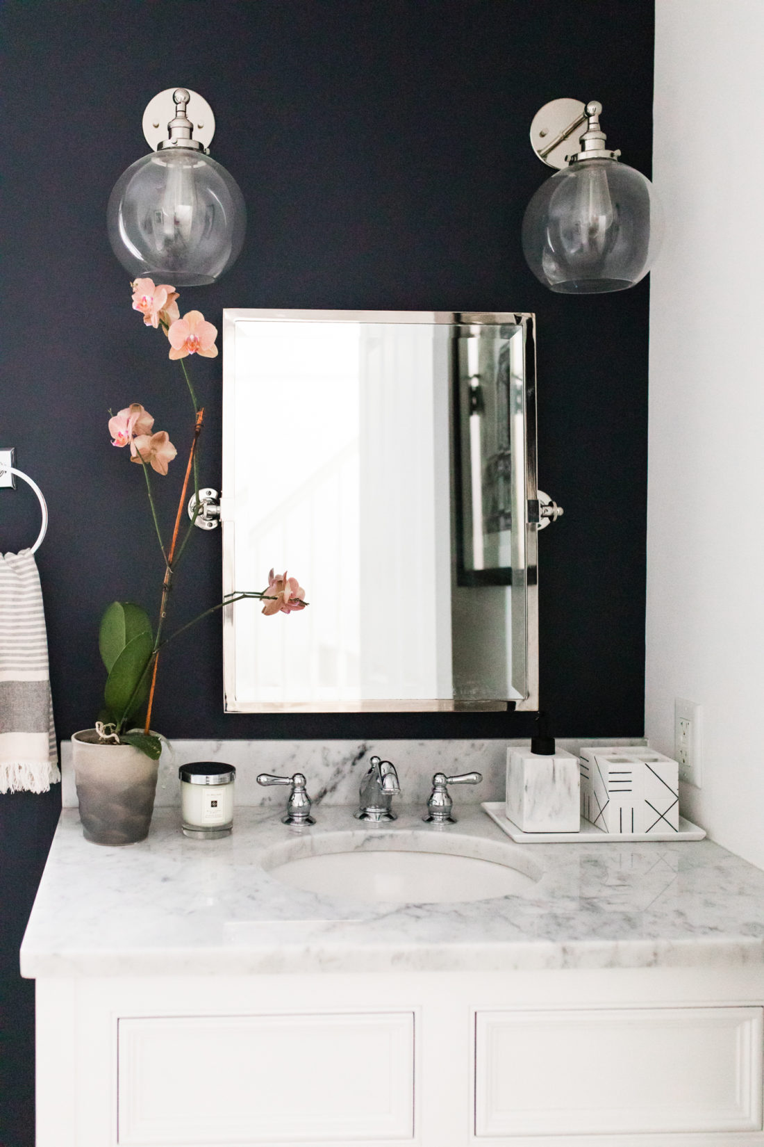 The wall sconces, vintage mirror, and marble vanity of Brenda Mierish Martino's Connecticut powder room