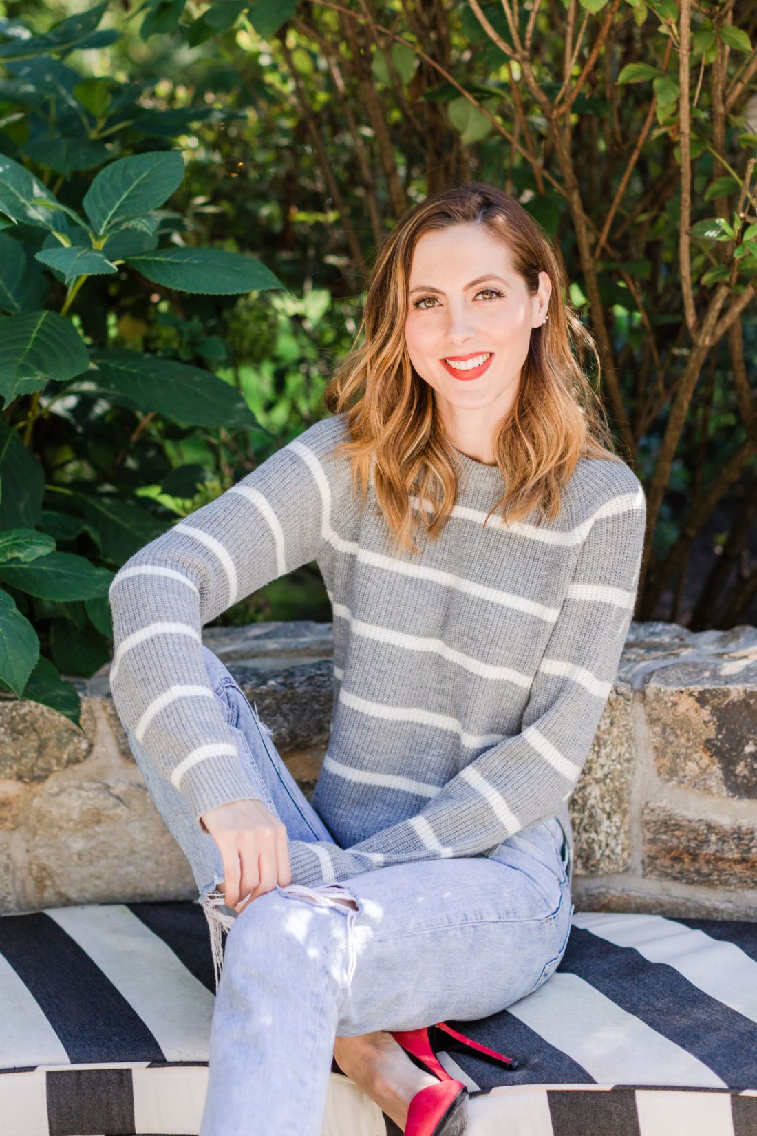 Brenda Mierish Martino wears a striped sweater and red heels out by her fire pit in Connecticut