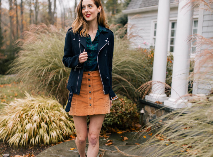Brenda Mierish Martino wears a plaid top, navy blue jacket, corduroy skirt, and black booties and walks down the pathway to her Connecticut home