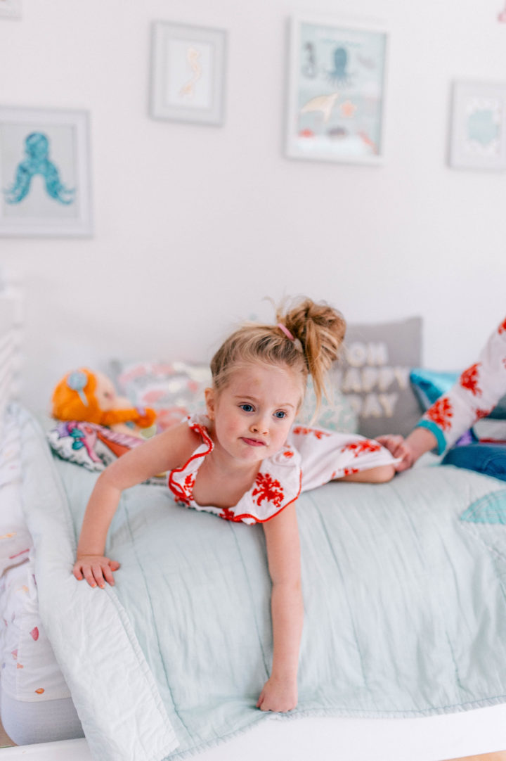 Brenda Mierish Martino's daughter Marlowe lies on her bed in a topknot a bright dress