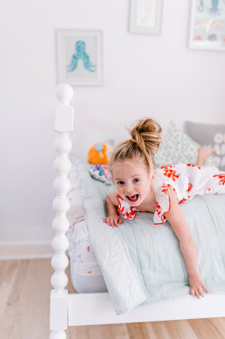 Brenda Mierish Martino's daughter Marlowe lies on her bed in a topknot a bright dress