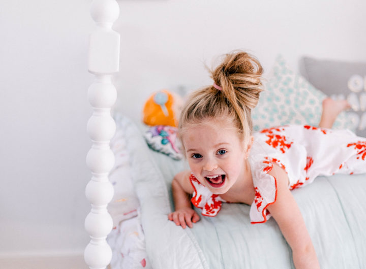 Brenda Mierish Martino's daughter Marlowe lies on her bed in a topknot a bright dress