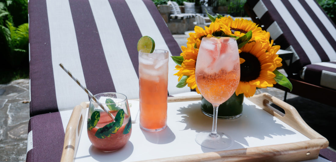Brenda Mierish Martino serves three different pink tinted cocktails to her guests poolside at her home in Connecticut